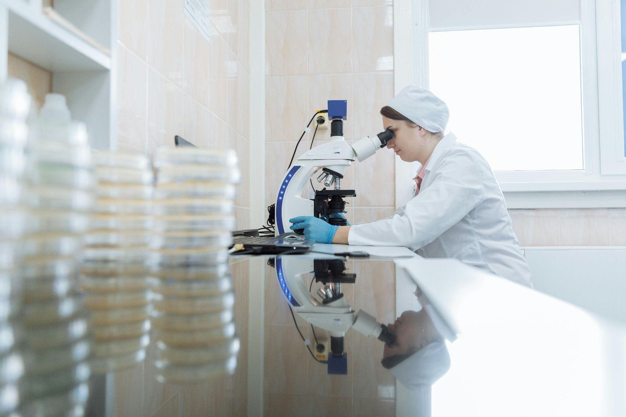 lady researcher looking through microscope